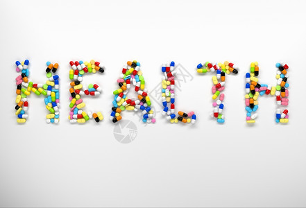 由白色背景的丰富多彩药丸和胶囊所创造的健康言语3d图片