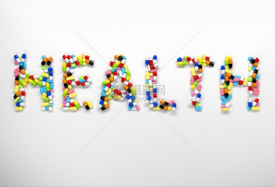 由白色背景的丰富多彩药丸和胶囊所创造的健康言语3d图片