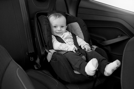 坐在汽车座椅上微笑的婴儿黑白照片图片