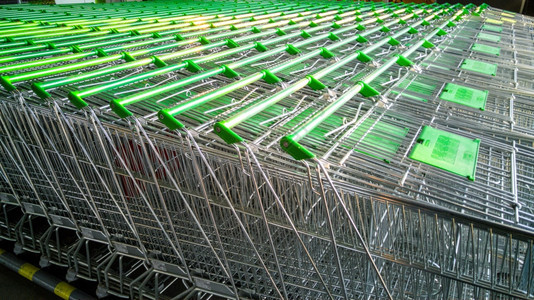 在超市装有绿色把手的购物车行图片