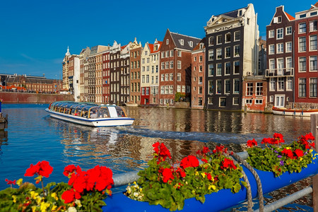 荷兰阳光明媚的阿姆斯特丹运河达拉克的美丽典型荷兰舞厅和旅游船图片