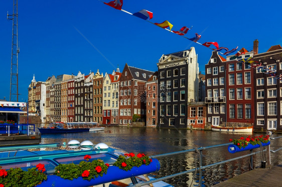 荷兰阳光明媚的阿姆斯特丹运河达拉克的美丽典型荷兰舞厅和旅游船图片