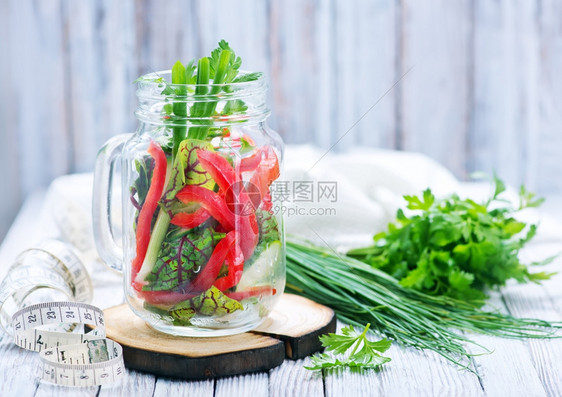 玻璃和桌子上的新鲜蔬菜沙拉图片