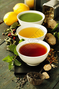 茶叶概念陶瓷碗中不同种类的茶叶和木本底黑茶绿色和红的成分图片