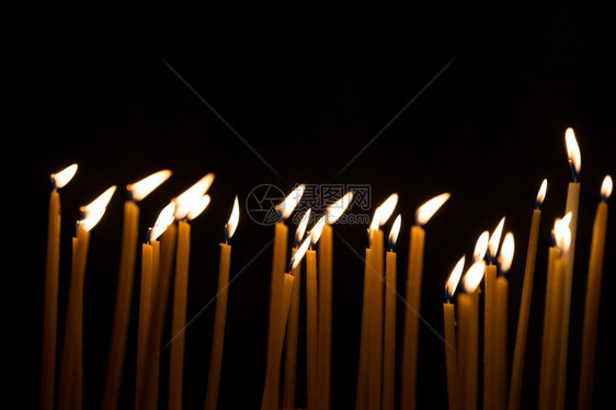 在黑色背景中隔离的蜡烛火焰图片