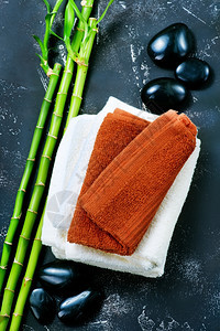 干净的毛巾黑石和竹子放在桌上图片