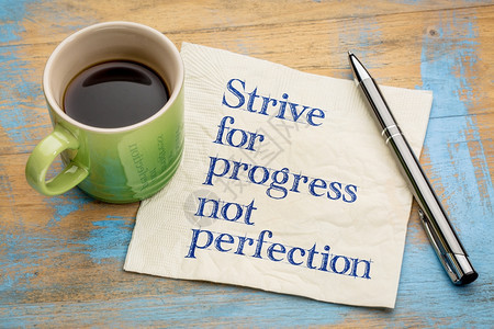 追求进步而不是完美手写在餐巾纸上一杯咖啡图片