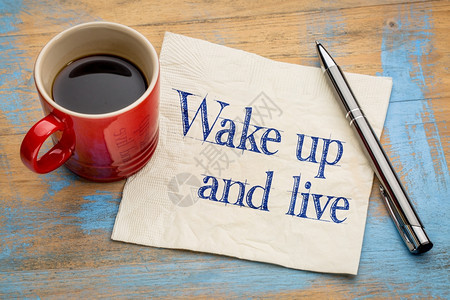 醒来后活生的手写在餐巾纸上加一杯咖啡图片