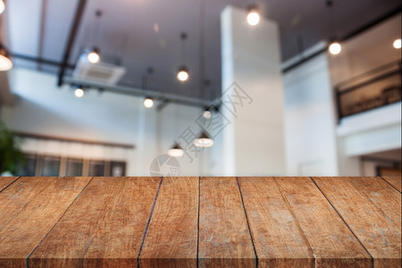 外观木制桌顶以抽象模糊的咖啡店内面为背景图片