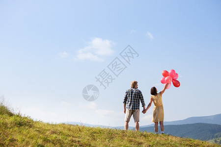 爱的年轻情侣天空背景有气球的年轻情侣图片