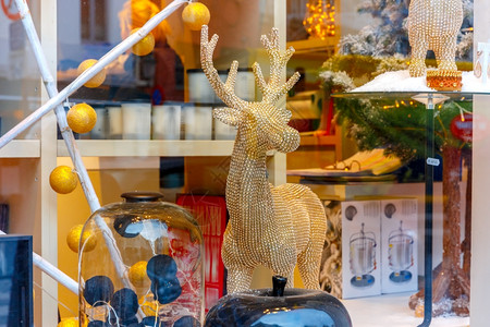 在比利时布鲁日的圣诞纪念品市场商店装饰和照亮的圣诞驯鹿狗和玩具图片