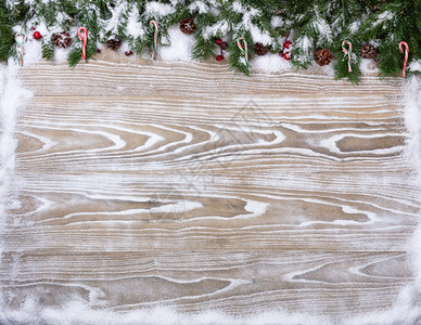 用于圣诞节概念的有雪层覆盖圆形枝糖果杖和松锥的精白木本底带有复制空间的顶部视图xAxA图片