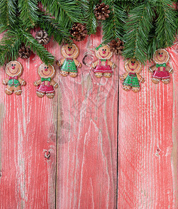 圣诞姜饼干和绿色树枝在生锈的红木上垂直格式图片