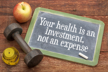 你的健康是一种投资而不是一种费用健康概念黑板牌标志用哑铃苹果和胶带测量器来对抗经风化的红漆谷仓木图片
