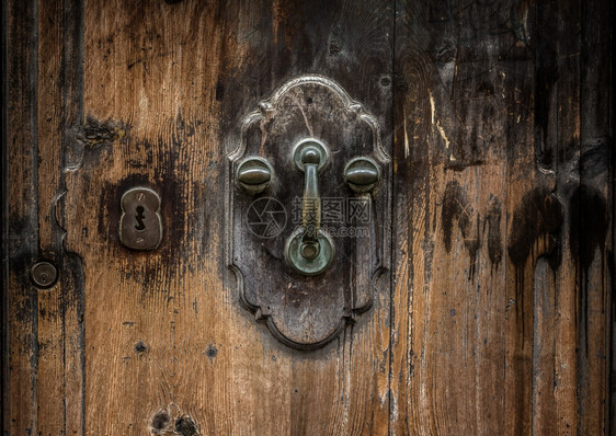 旧金属门粗木背景的敲门手图片