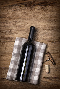 红葡萄酒瓶和木制桌底的酒瓶和酒瓶带有复制空间的顶端视图图片