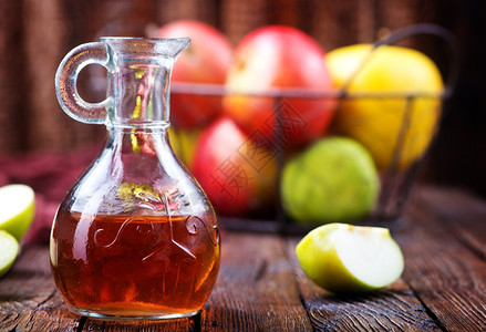 瓶中和桌上的苹果醋背景图片