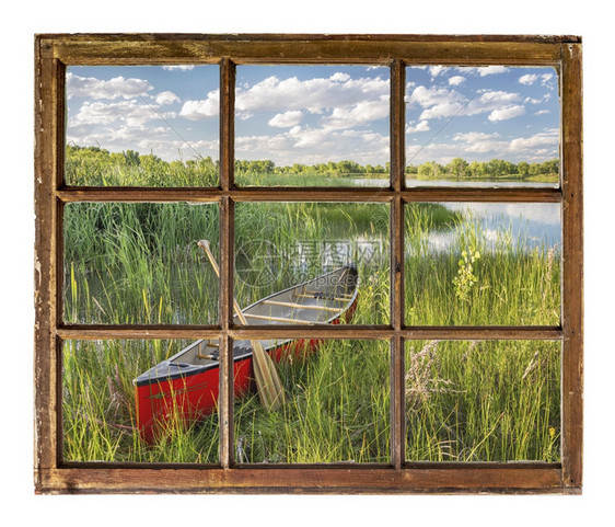 湖岸边的红独木舟在夏季的风景中通过古老的冷用脏玻璃砸碎的窗户图片