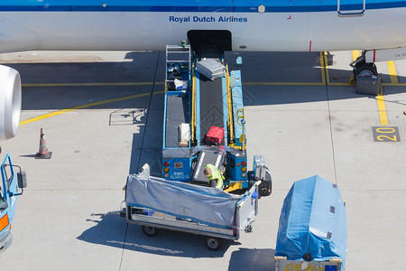 在荷兰阿姆斯特丹奇福机场的飞机装载行李图片
