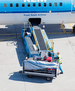 在荷兰阿姆斯特丹奇福机场的飞机装载行李图片