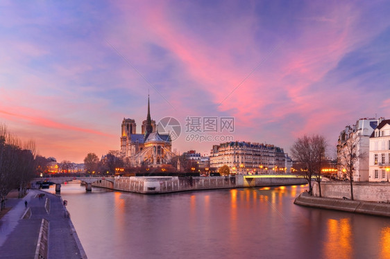 法国巴黎圣母教堂塞纳河和法国巴黎圣母教堂上空的光辉日落图片