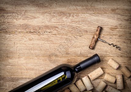木背景上的葡萄酒瓶和软木图片