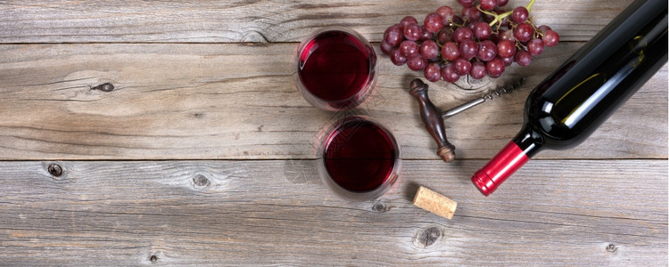 一瓶红酒古老的colscorscrew葡萄和在生锈木板上杯子的玻璃图片