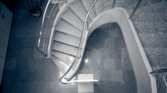 现代建筑中石块弯曲楼梯的单色图像图片