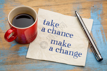 抓住一个机会做出改变鼓舞人心的笔迹在餐巾纸上与一杯咖啡图片