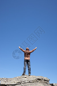 人站在山顶蓝色的天空上图片