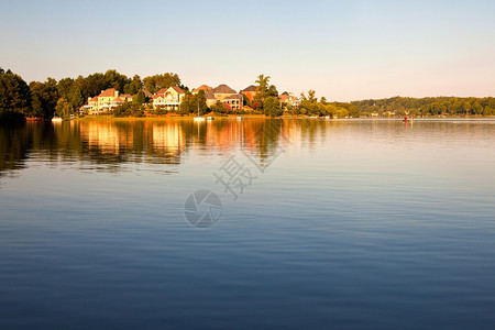与湖泊和房屋相邻的乡村风景图片