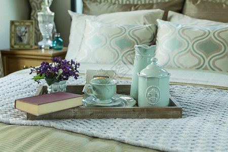装饰盘托配有书籍茶叶和床上花朵图片