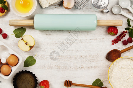 烘烤工具和原料面粉滚针鸡蛋计量勺子水果和浆放在旧木板上图片