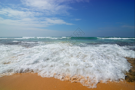 海和沙滩的泡沫波图片