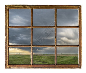 内布拉斯加农田上空的暴云和雨从古老坚固用脏玻璃砸的窗户上可以看到图片