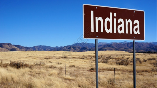 印地安那路标有蓝天和荒野印地安那棕色路标图片