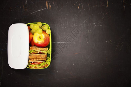 学校午餐盒配有三明治苹果葡萄和胡萝卜图片