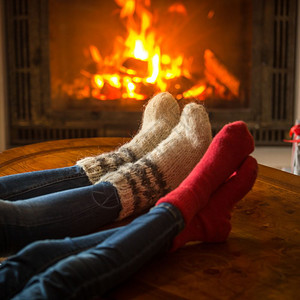 家庭穿着袜子坐在小屋里烧壁炉图片