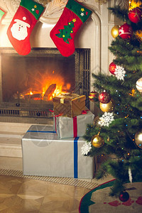 客厅圣诞树背景烧着的壁炉装有用于礼品的传统丝袜图片