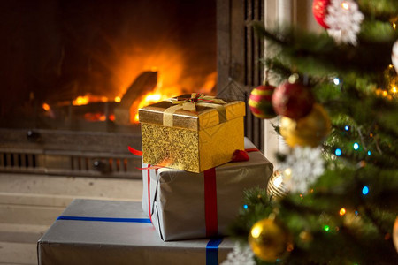 高堆圣诞礼物和燃烧的壁炉图片