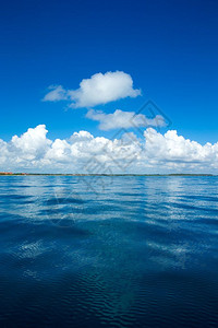 蓝云在平凉的海面上云在蓝的天空上阳光反射图片