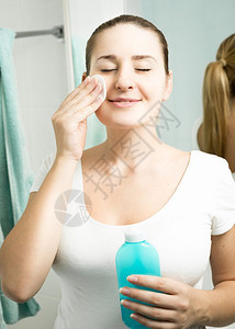 美丽的微笑女士在浴室用湿润的液图片