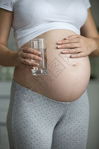 孕妇拿着水杯的近照片图片