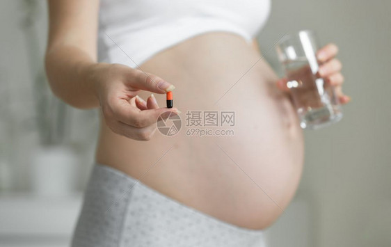 孕妇用水杯和药丸的近照片图片