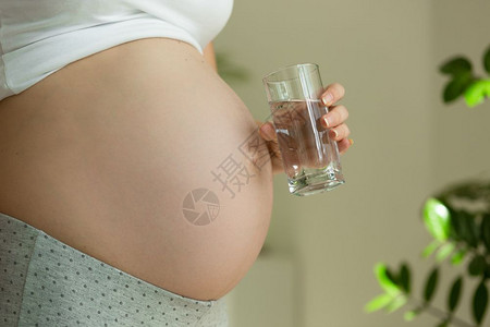 孕妇用杯水的近视图像图片