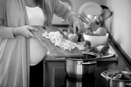 孕妇烹煮蔬菜汤的黑白近身照片图片