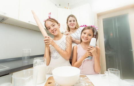 母亲和两个女儿在做饭时厨房摆姿势图片