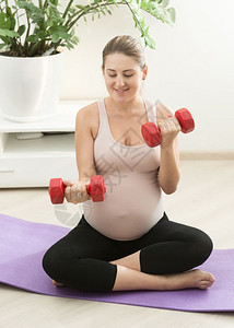 怀孕妇女在家里用哑铃做运动图片