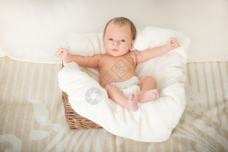 2个月大的婴儿男孩坐在篮子中被毯覆盖图片