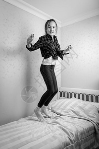 黑白快乐的少女在床上跳高图片